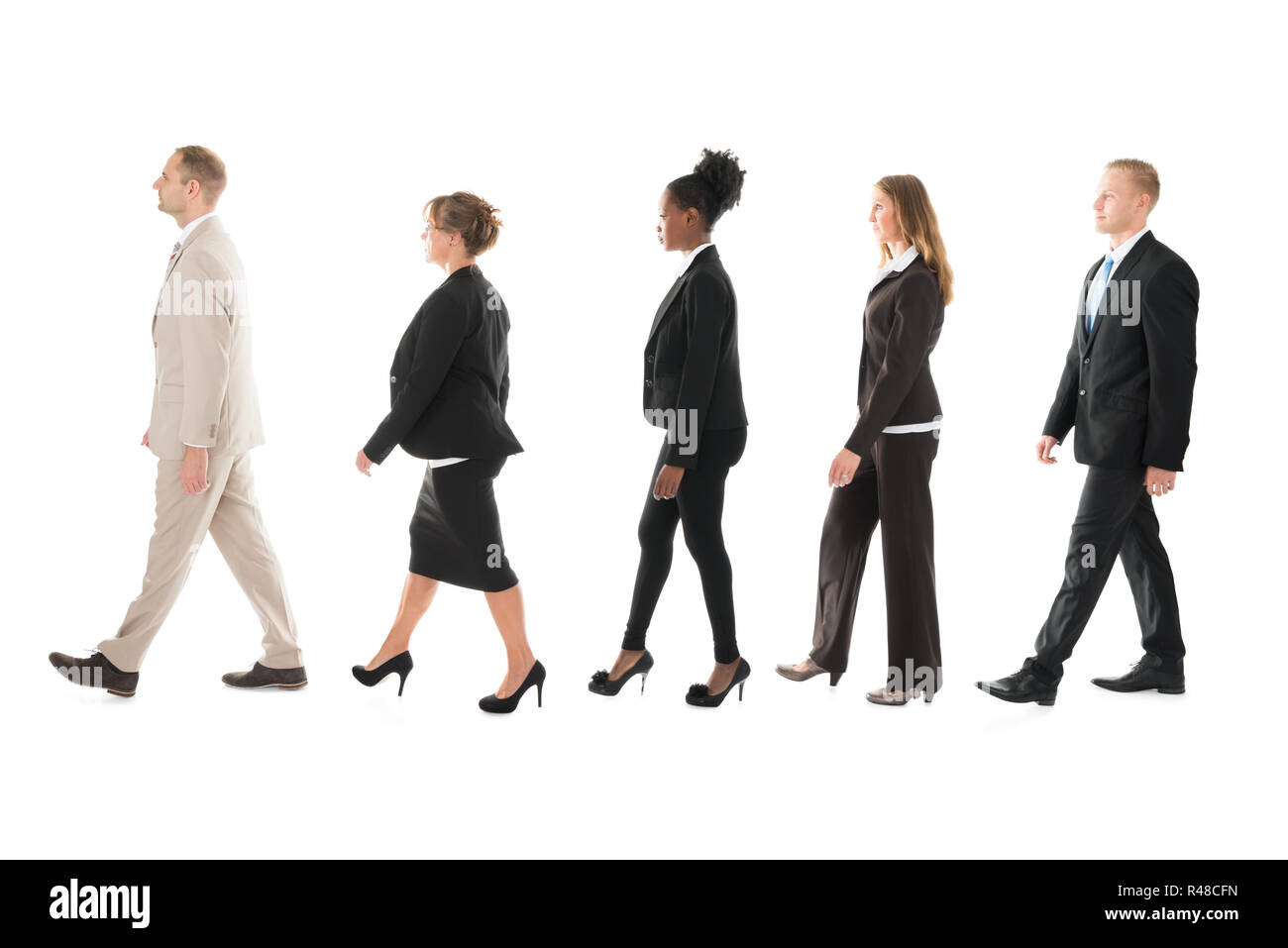 Side View Of Business Team Walking In Row Stock Photo