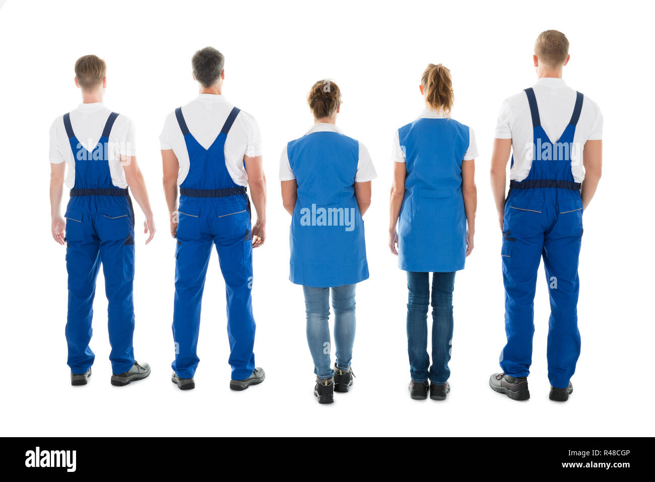 Rear View Of Male And Female Janitors Standing In Row Stock Photo