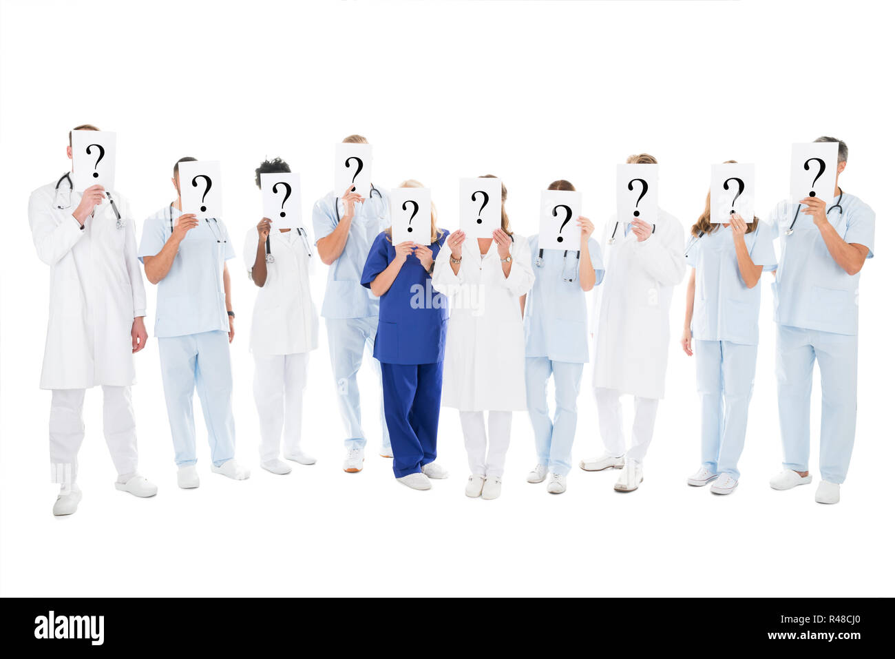 Medical Team Covering Faces With Question Mark Signs Stock Photo