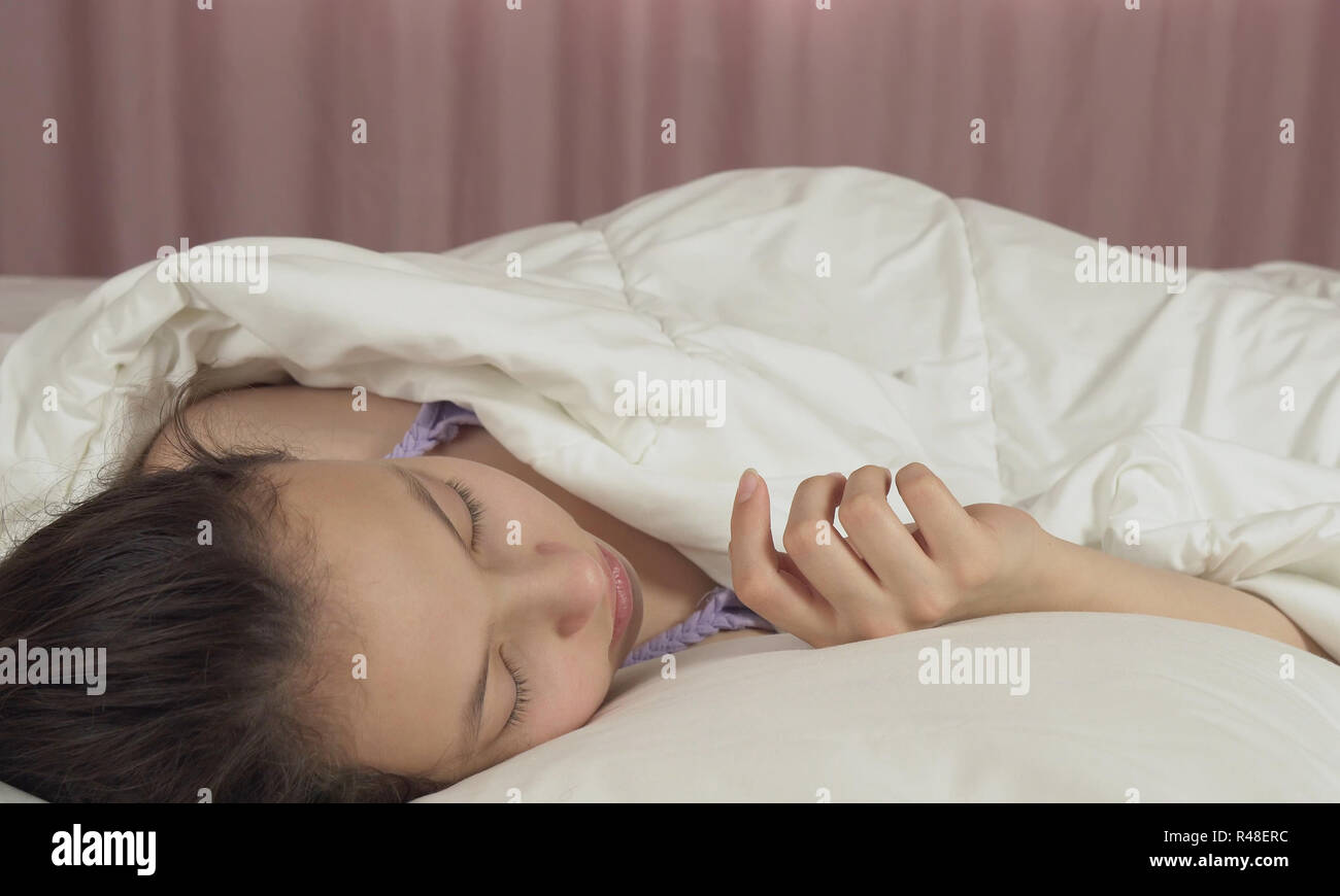 Beautiful teen girl sleeping sweetly in bed Stock Photo