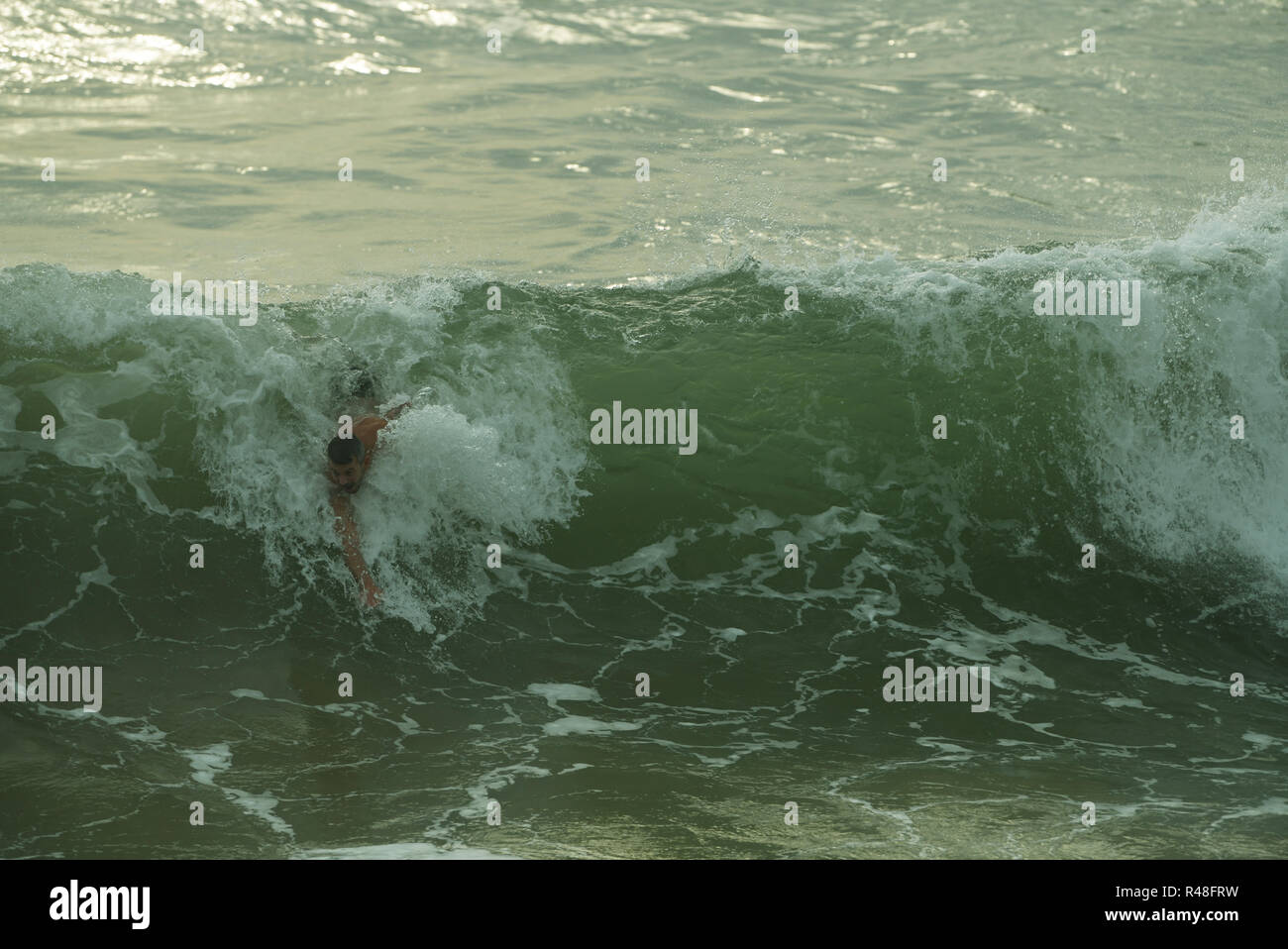 Durban, KwaZulu-Natal, South Africa, single adult male bodysurfer dynamically accelerating down face of breaking wave Stock Photo