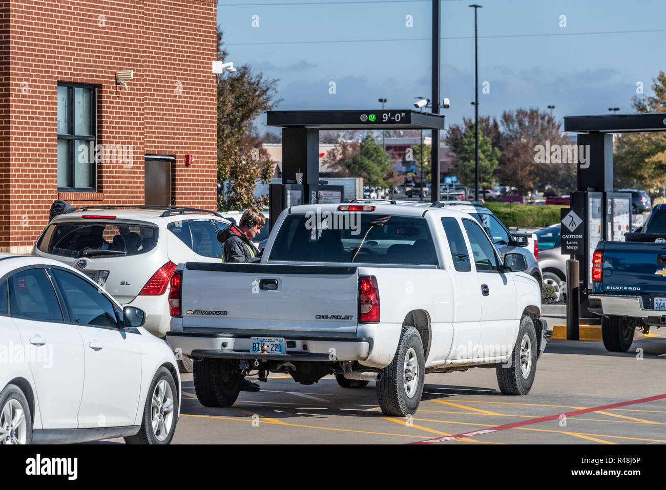 Chick-fil-A employees taking customer orders in double drive-thru lanes at busy Chick-fil-A restaurant in Muskogee, Oklahoma. (USA) Stock Photo