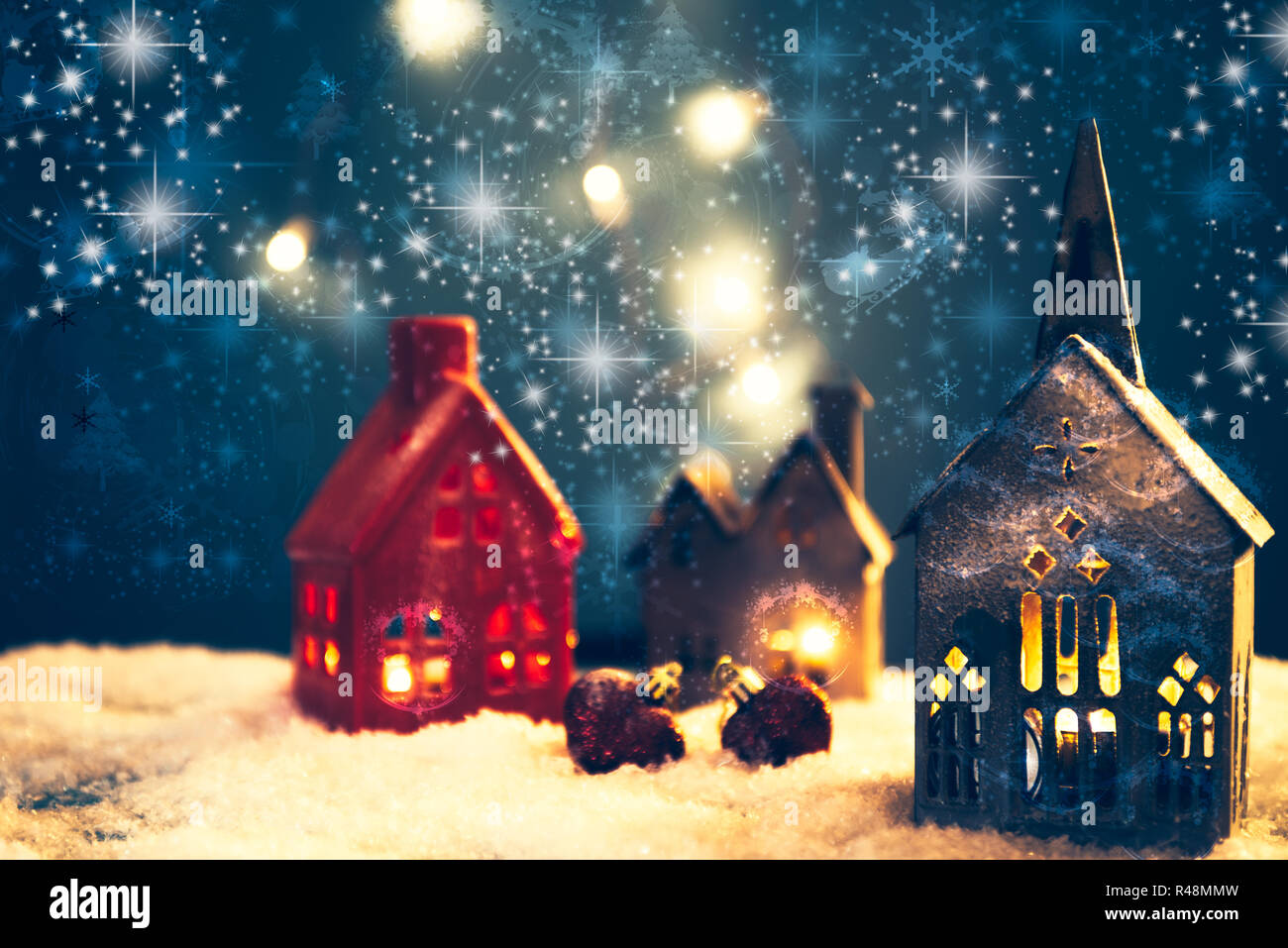 Christmas village made with different candle house, snow, blue background, and beautful bokeh and effect adding mood to the photo, space for adding yo Stock Photo