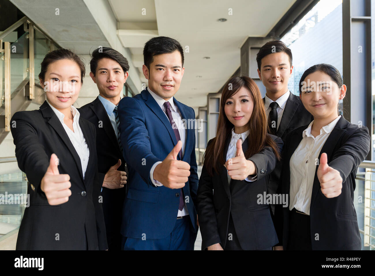 Group of business people showing thumb up gesture Stock Photo - Alamy
