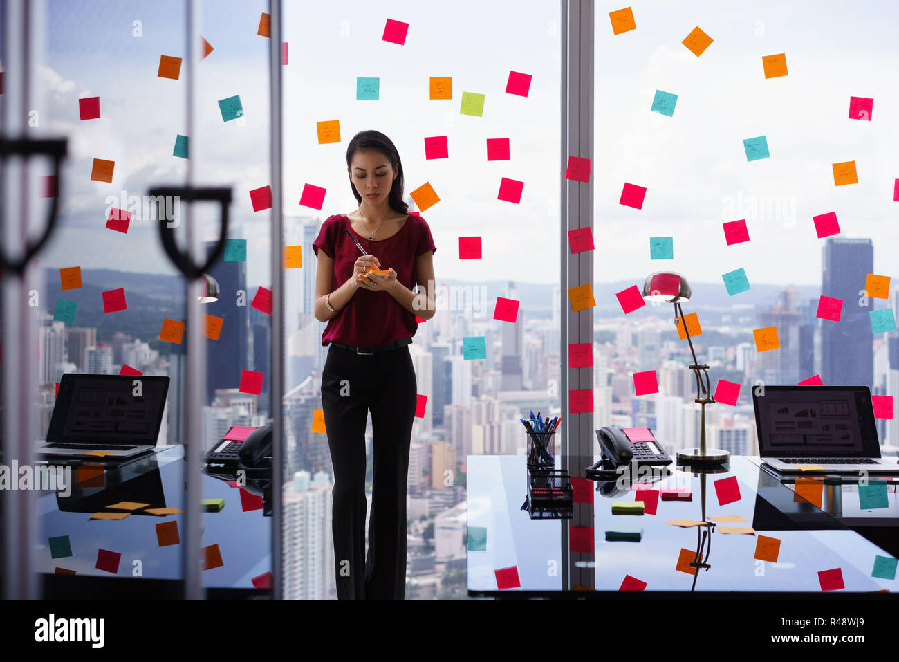 Busy Person Writing Many Sticky Notes On Large Window Stock Photo