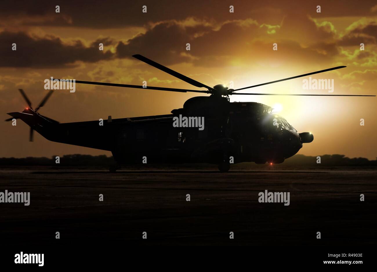 Military helicopter on airfield during sunset Stock Photo - Alamy
