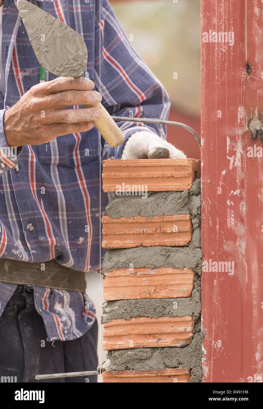 Bricklayer working in construction site of brick wall Stock Photo - Alamy