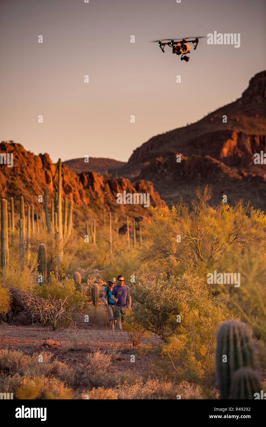 Two actors in the desert being filmed by a drone aircraft Stock Photo ...