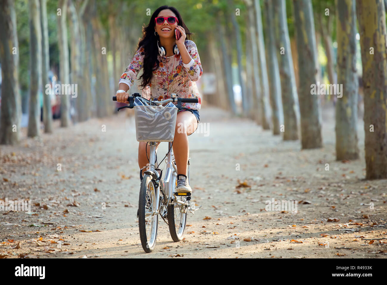 Pretty young girl riding bike and talking on the phone Stock Photo - Alamy