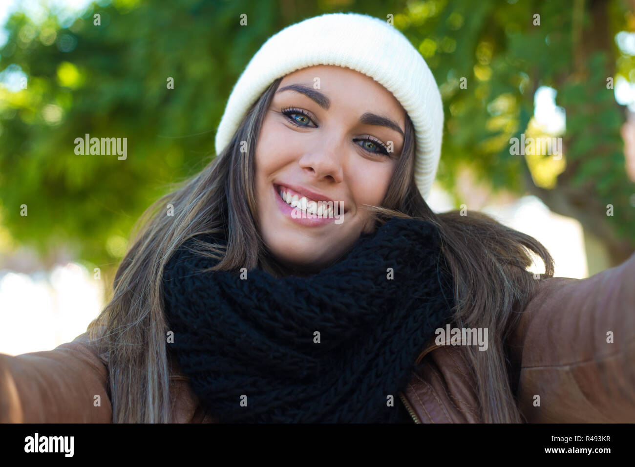Portrait of beautiful girl taking a selfie with mobile phone in city ...