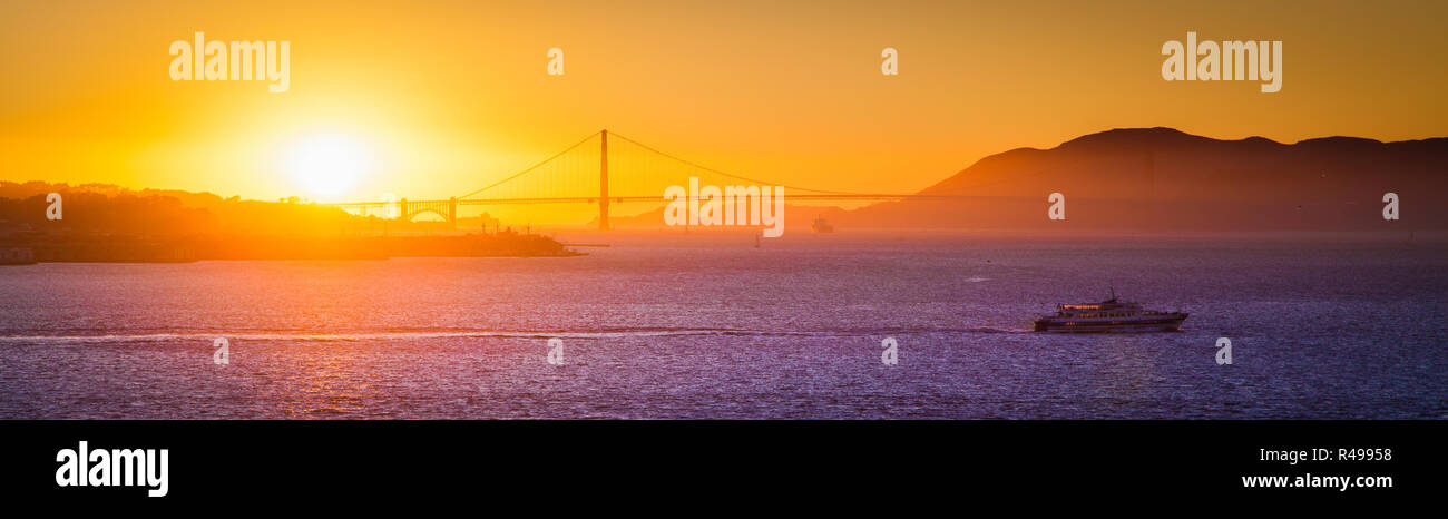 Panoramic view of famous Golden Gate Bridge illuminated in beautiful golden evening light at sunset in summer, San Francisco Bay Area, California, USA Stock Photo