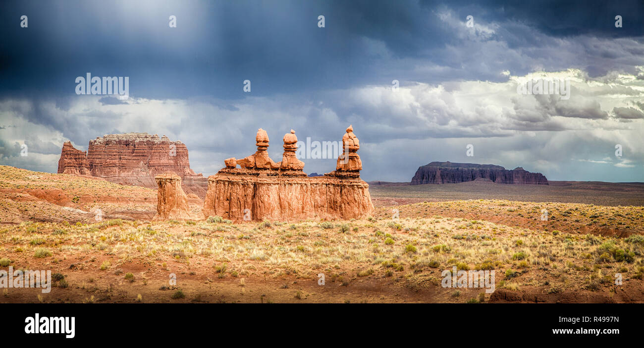 Panoramic view of stunning Hoodoos sandstone formations in famous Goblin Valley State Park on a beautiful sunny day with dark clouds and thunderstorm  Stock Photo