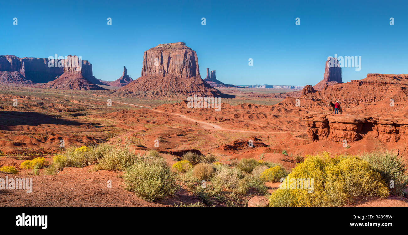 Classic panoramic view of scenic Monument Valley with horse rider at famous John Ford's Point  in beautiful golden evening light at sunset in summer Stock Photo