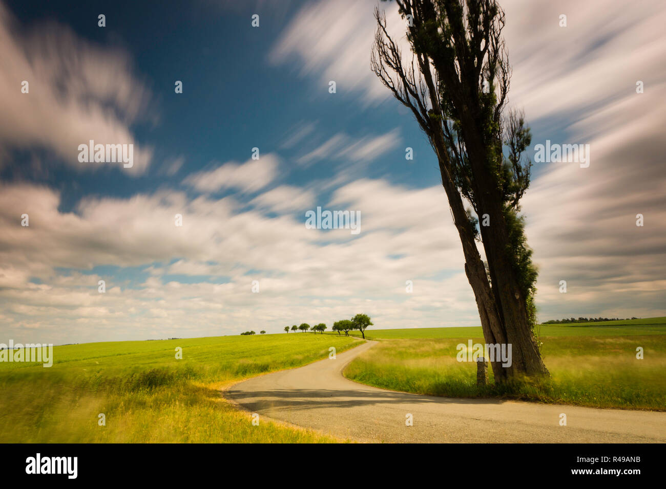 landscape in summer and clouds pulling in a long exposure on the way to the horizon Stock Photo