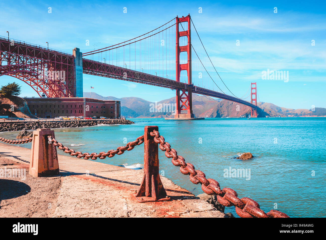 Classic view of famous Golden Gate Bridge with Fort Point National Historic Site on a beautiful sunny day with blue sky and clouds, San Francisco, USA Stock Photo