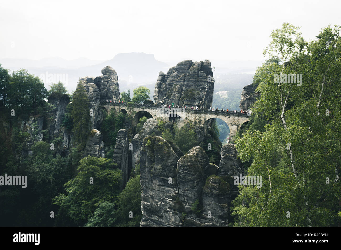 Beautiful panoramic view of famous Bastei Bridge with Elbe Sandstone mountains in Saxon Switzerland National Park on a moody day, Saxony, Germany Stock Photo