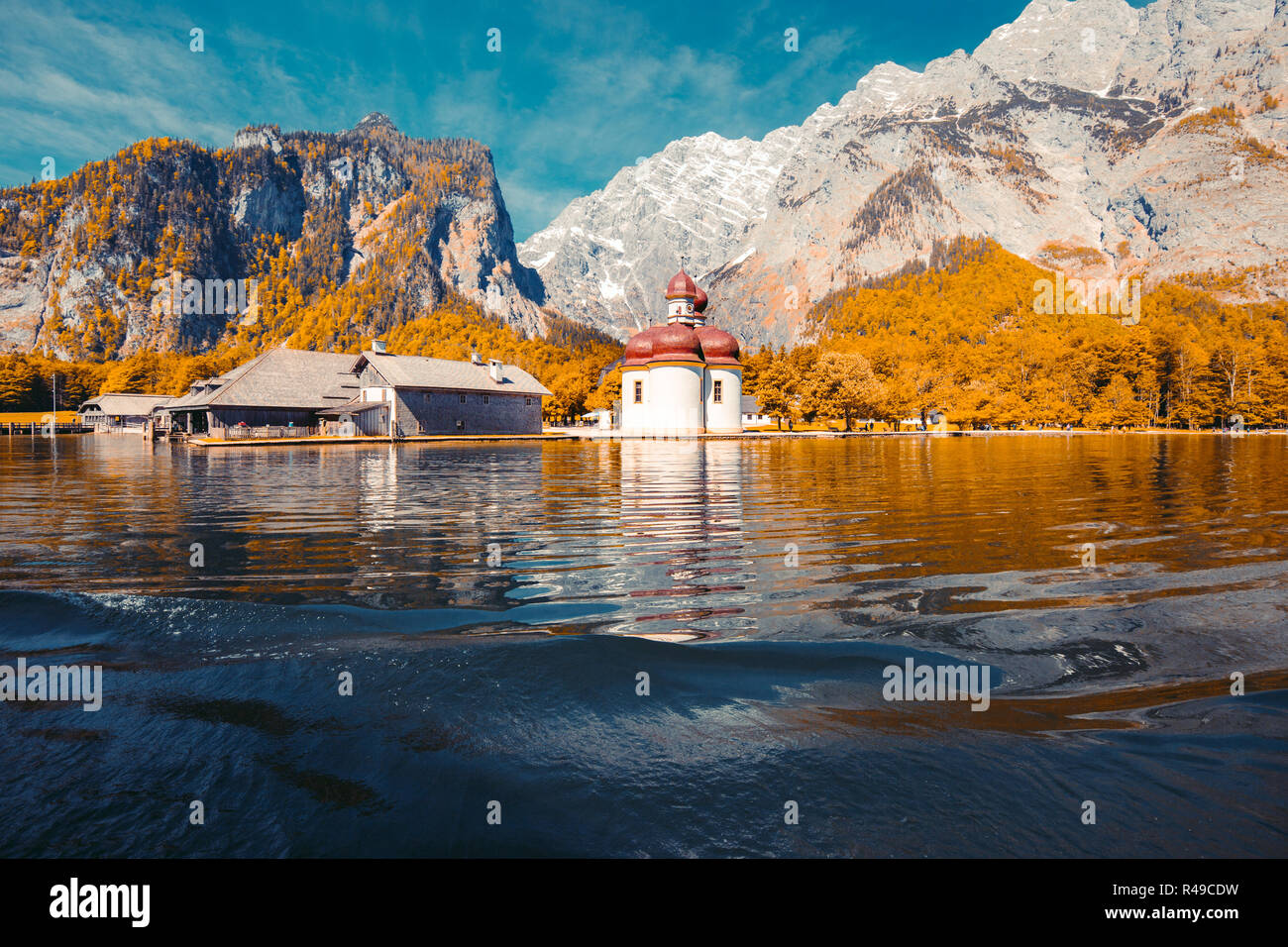 Classic panoramic view of Lake Konigssee with world famous Sankt Bartholomae pilgrimage church and Watzmann mountain on a beautiful sunny day in fall, Stock Photo