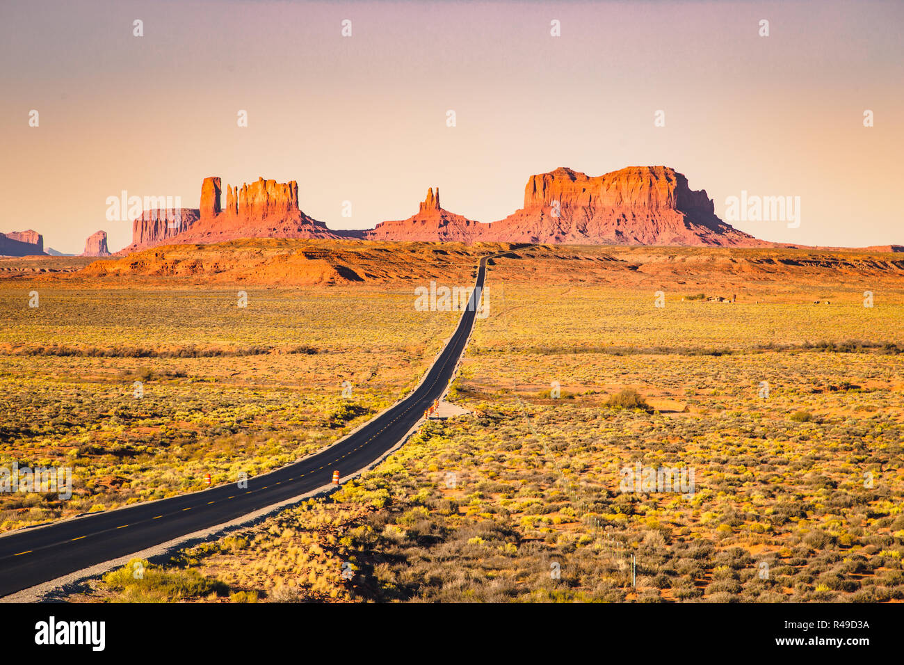 Classic panorama view of historic U.S. Route 163 running through famous Monument Valley in beautiful golden evening light at sunset in summer, Utah, U Stock Photo