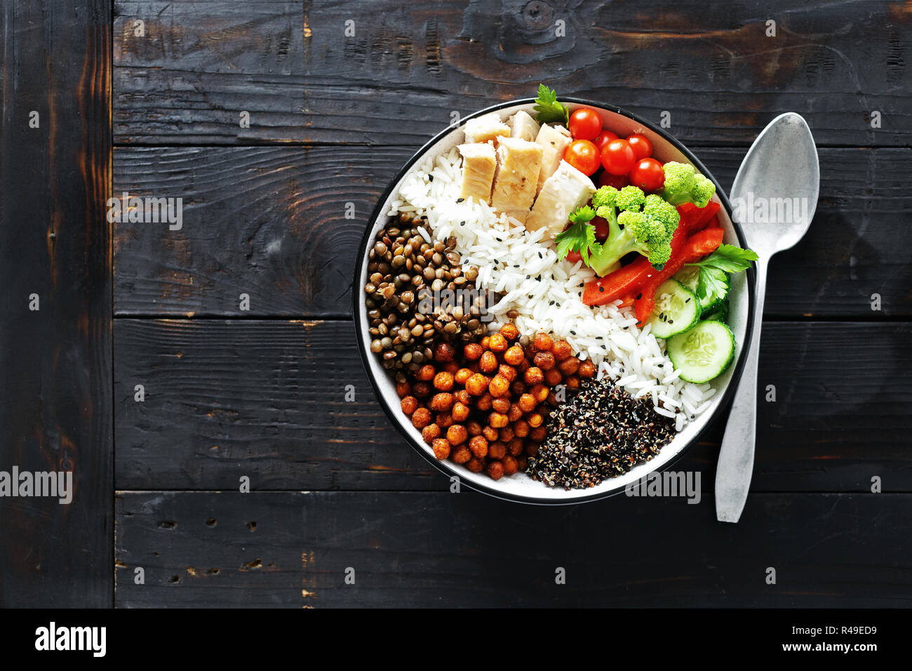 Quinoa, lentil and chickpeas vegetable vegetarian buddha bowl on dark wooden background top view. Healthy food Stock Photo