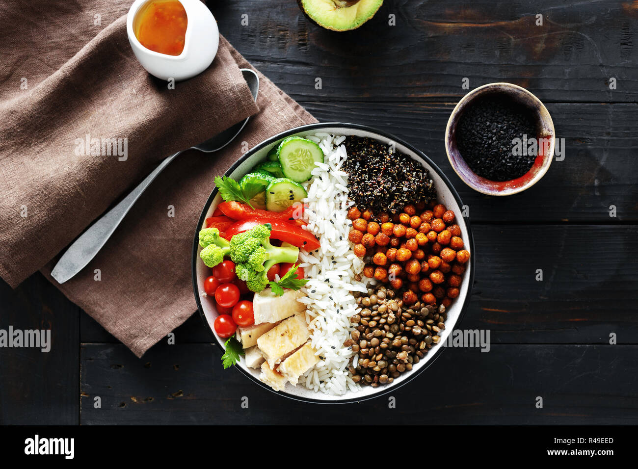 Quinoa, lentil and chickpeas vegetable vegetarian buddha bowl on dark wooden background top view. Healthy food Stock Photo