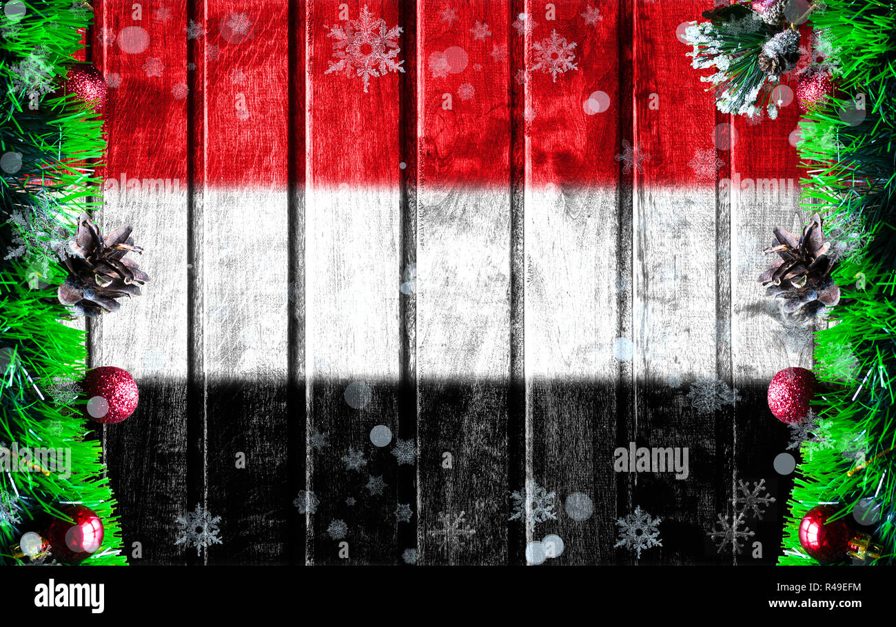 Wooden Christmas background with blurred flag of Yemen. There is a