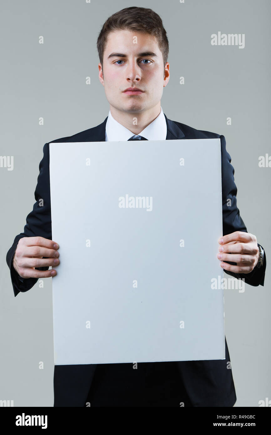 Businessman holding empty white placard showing copy space Stock Photo ...