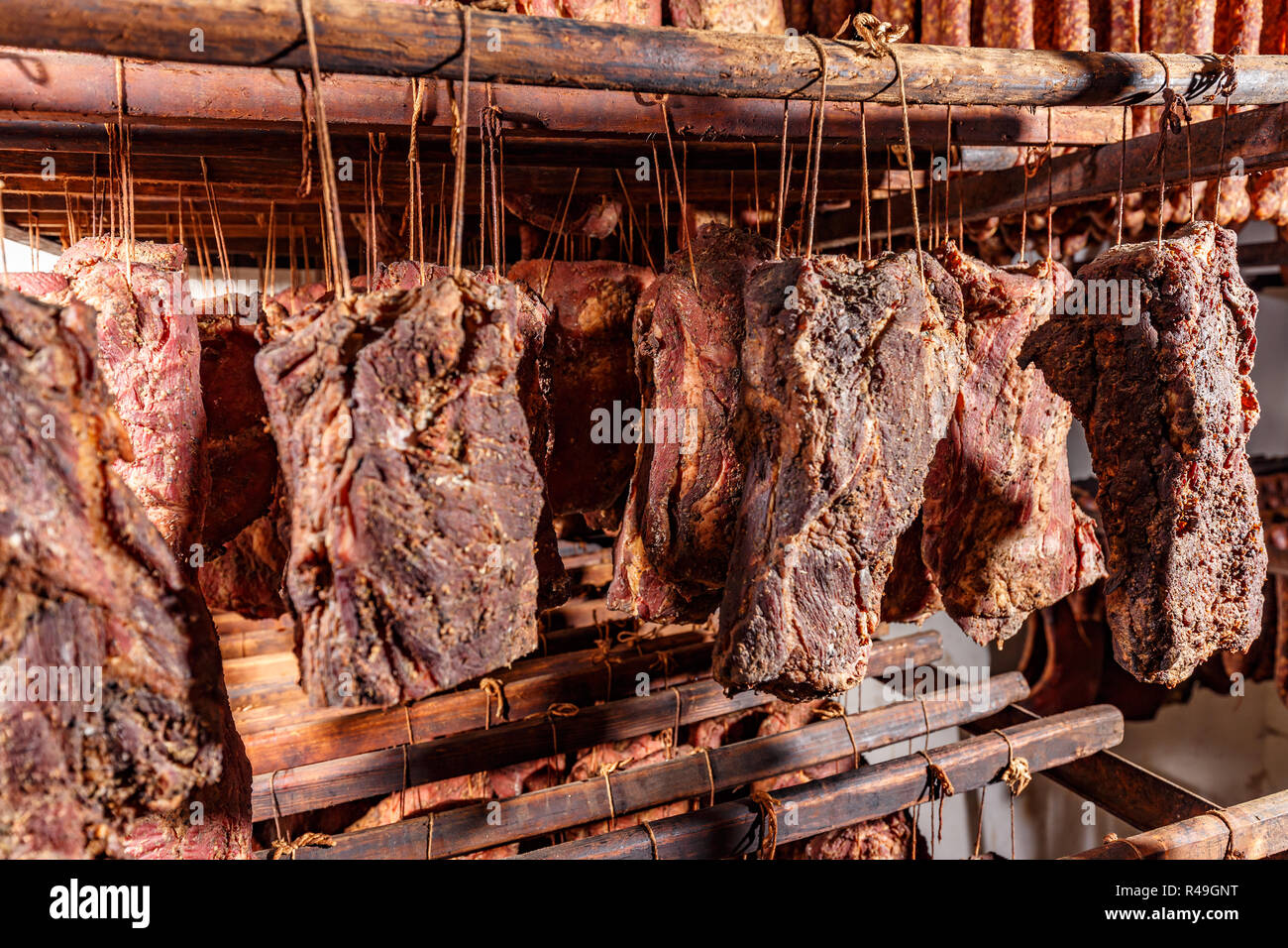 Smoked pork chop factory large amounts made at once on hooks in meat smoking chamber Stock Photo