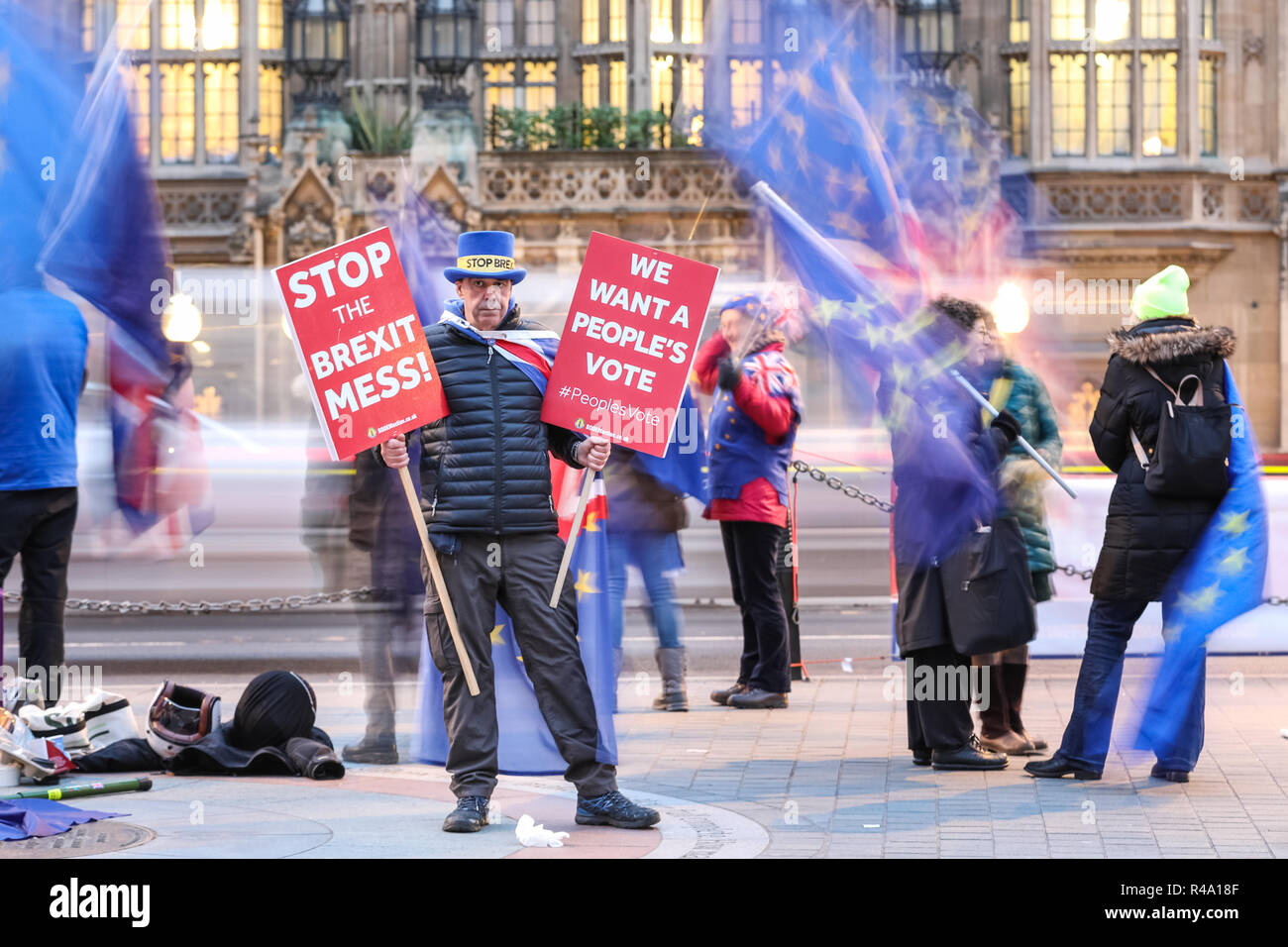 Westminster, London, 26th Nov 2018. SODEM founder Steve Bray, often referred to as the 'Shouty Man', stands with his placards as fellow protesters wave flags around him . Anti-Brexit Protesters from SODEM (Stand of Defiance European Movement) rally outside the Houses of Parliament and near media reporters and crews at College Green in Westminster. Credit: Imageplotter News and Sports/Alamy Live News Stock Photo