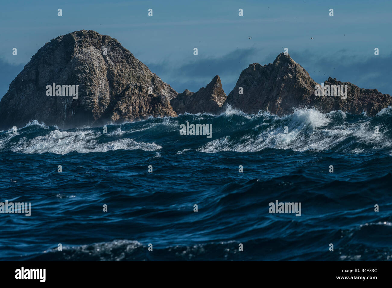 The Farallon islands jutting out of the pacific ocean as big waves roll