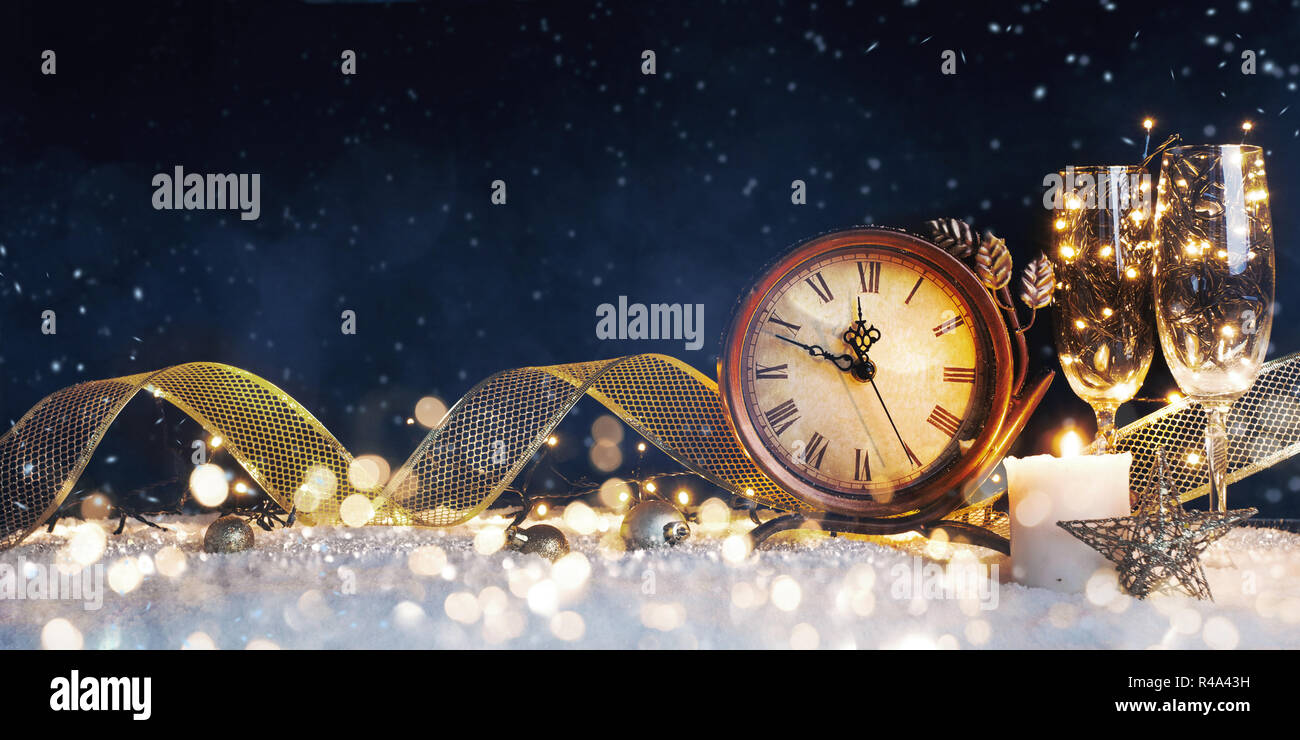 New Year's clock with christmas decorations on snow Stock Photo