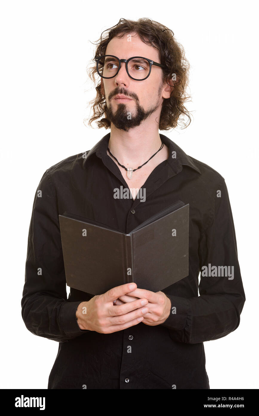 Handsome Caucasian man holding book while thinking Stock Photo