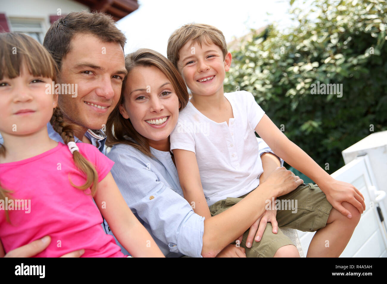 Happy family standing in front of new home Stock Photo - Alamy