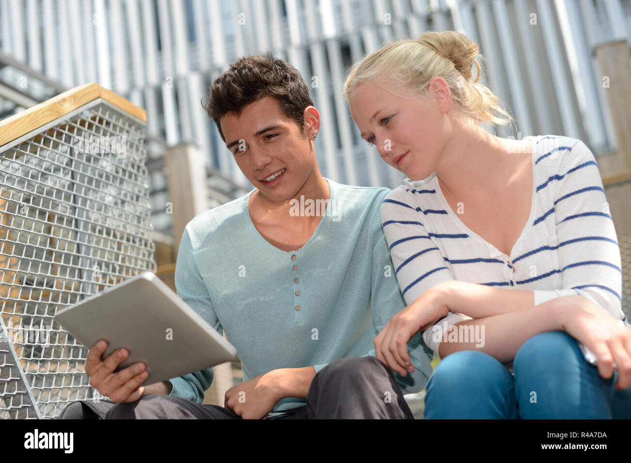 Students in school yard using digital tablet Stock Photo
