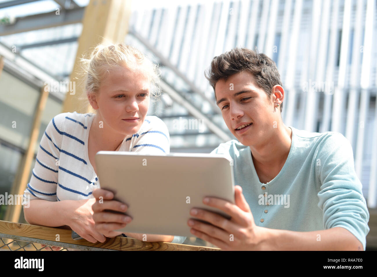 Students in school yard using digital tablet Stock Photo