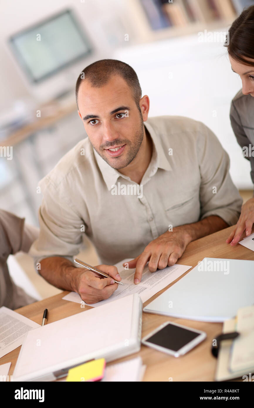 Portrait of young man filling in application form Stock Photo - Alamy