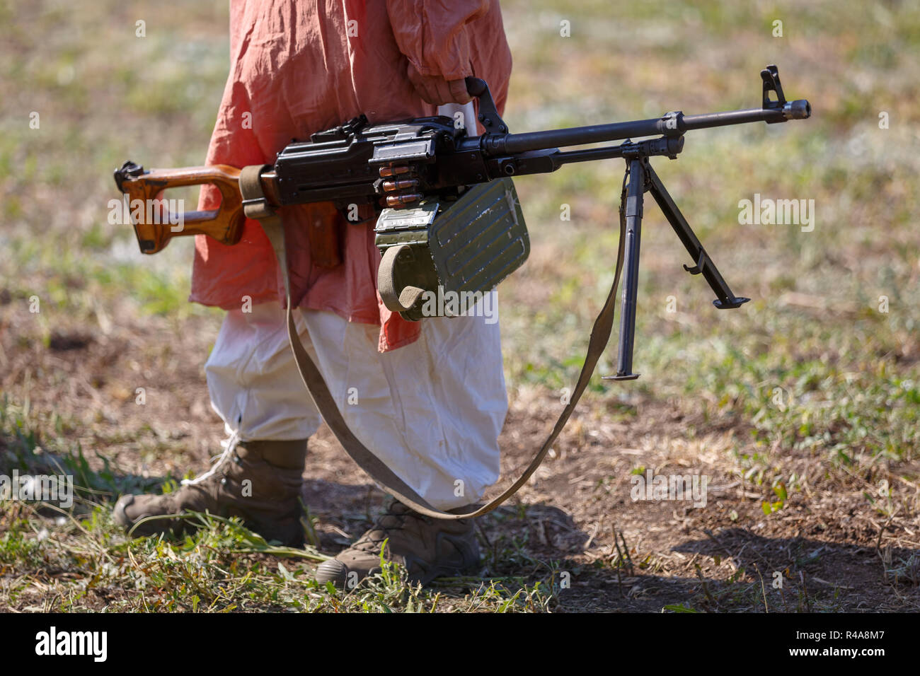 SAMBEK, ROSTOV REGION, RUSSIA, AUGUST 19, 2018: A man in traditional dress is carrying the russian machine gun Stock Photo