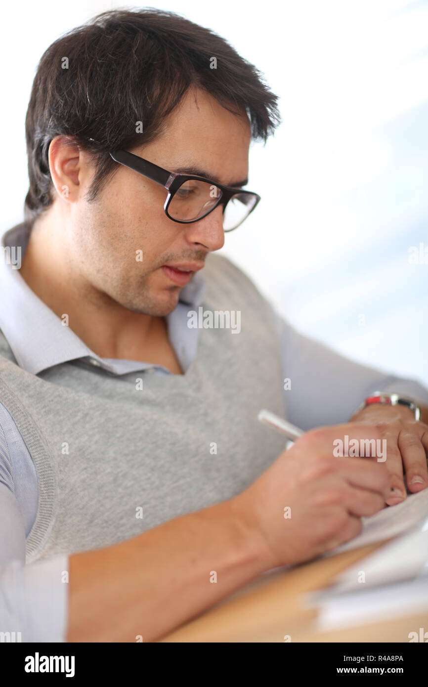 Portrait of young man filling in application form Stock Photo - Alamy