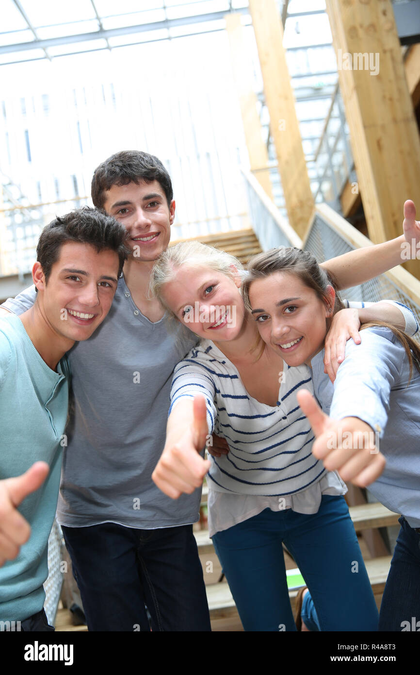 Group of cheerful students showing thumbs up Stock Photo - Alamy