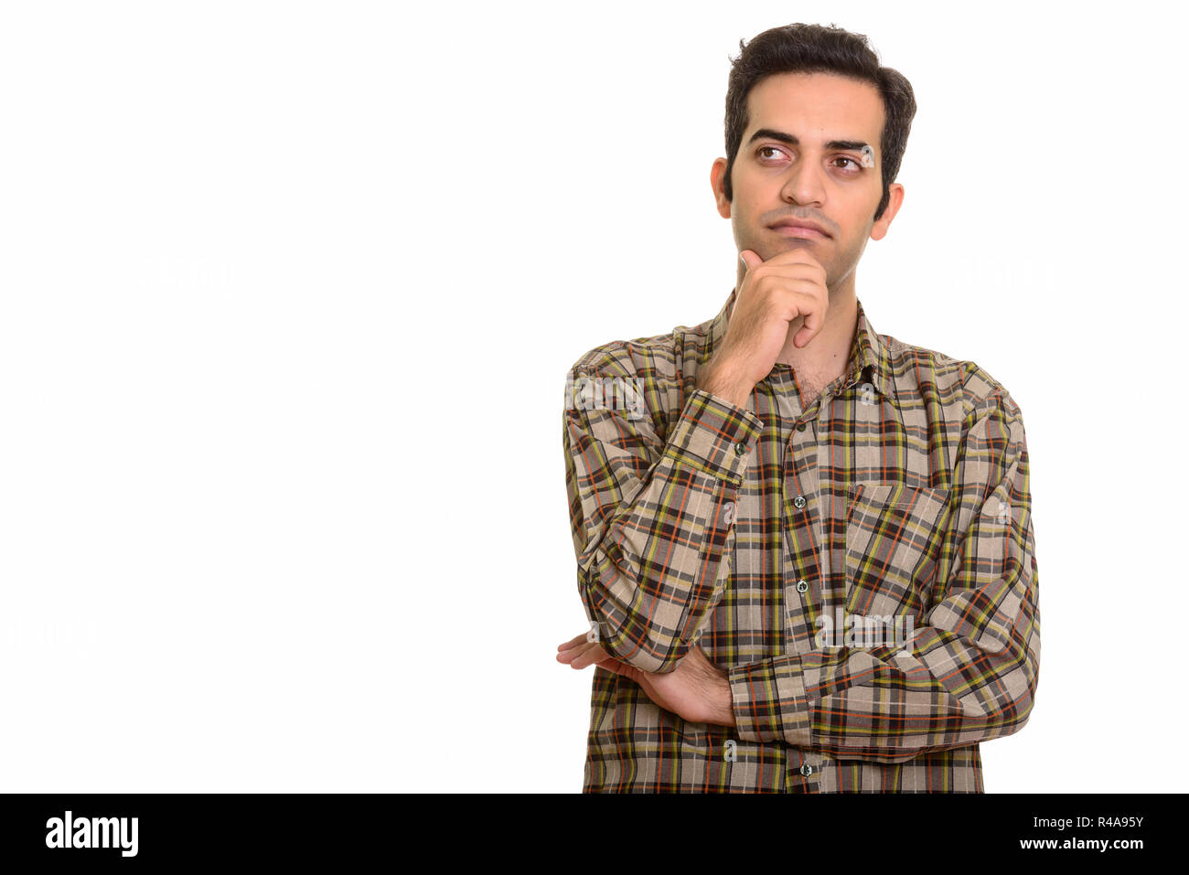 Portrait of young Persian man thinking and looking up Stock Photo