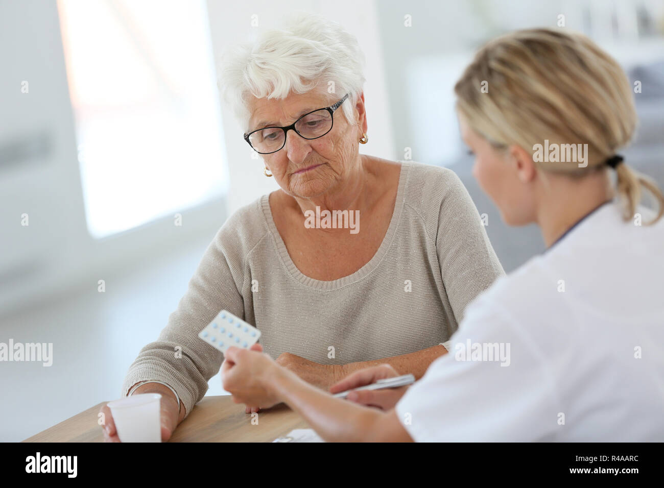 Doctor giving pills to elderly woman Stock Photo Alamy