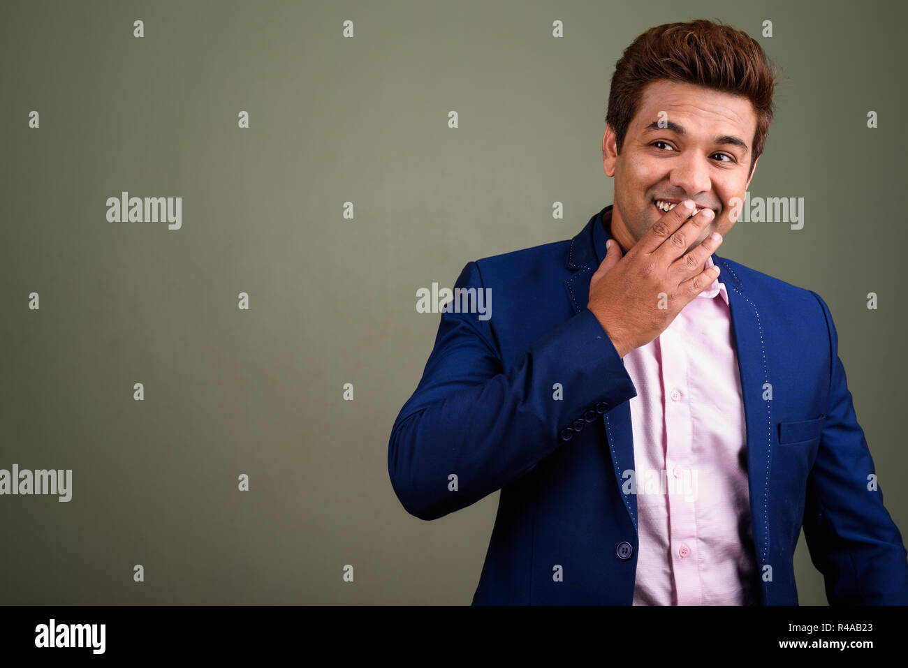Indian businessman wearing suit against colored background Stock Photo