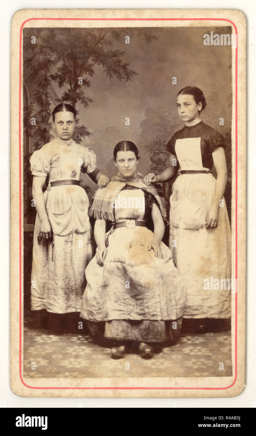Original and rare Victorian Carte de Visite (CDV) 1800's studio portrait of group of 3 poor looking Lancashire cotton mill girl workers wearing clogs and dirty aprons from the studios of Albert Parker, Blackpool, Lancashire, England, U.K. circa 1870's Stock Photo
