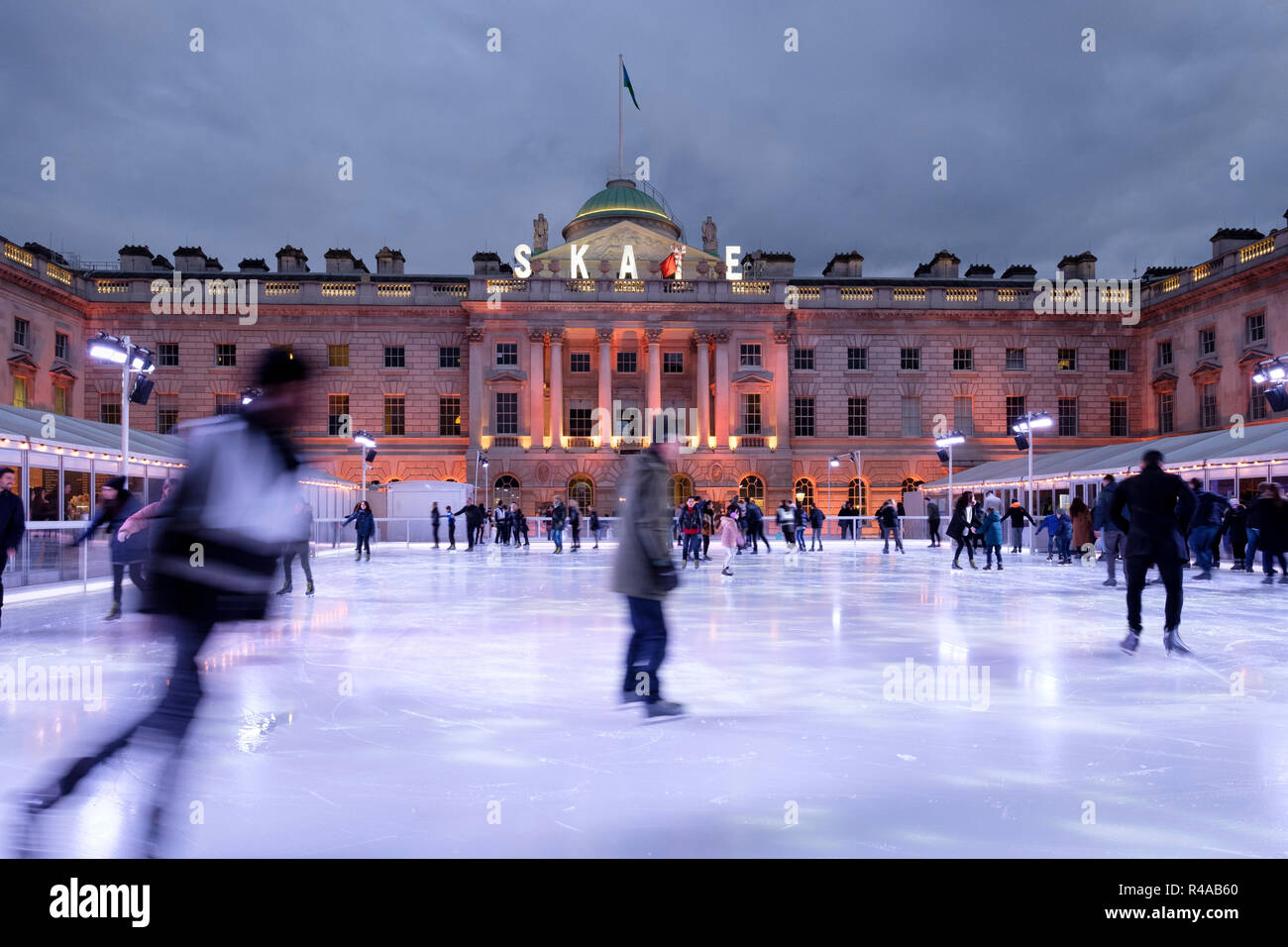 Skaters at dusk on the pop-up ice rink at Somerset House, London, England Stock Photo