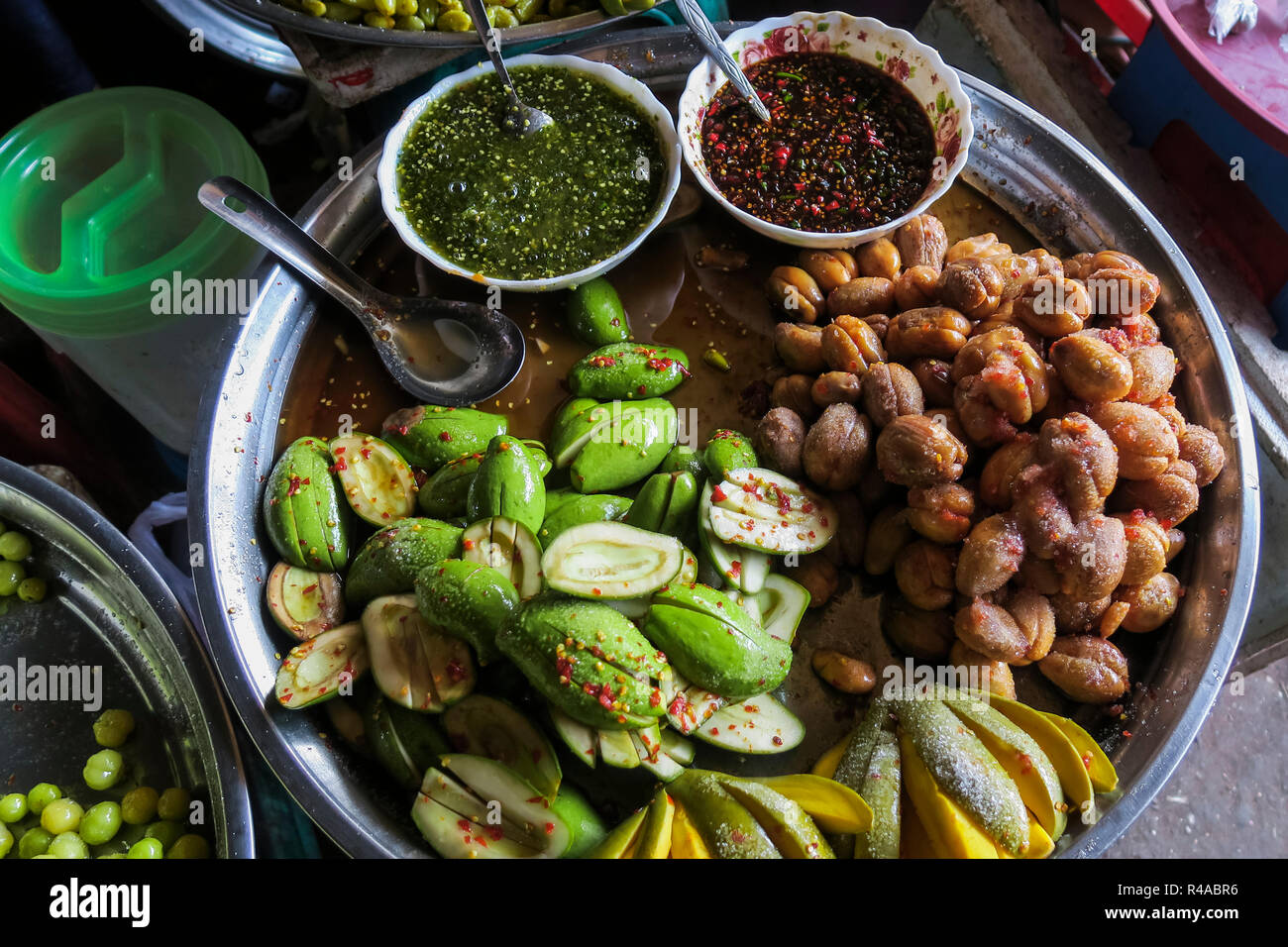 Green mango & chayote with chili salsas at Psar Chas Old Market in the centre of Siem Reap, the important north west tourist town; Siem Reap, Cambodia Stock Photo