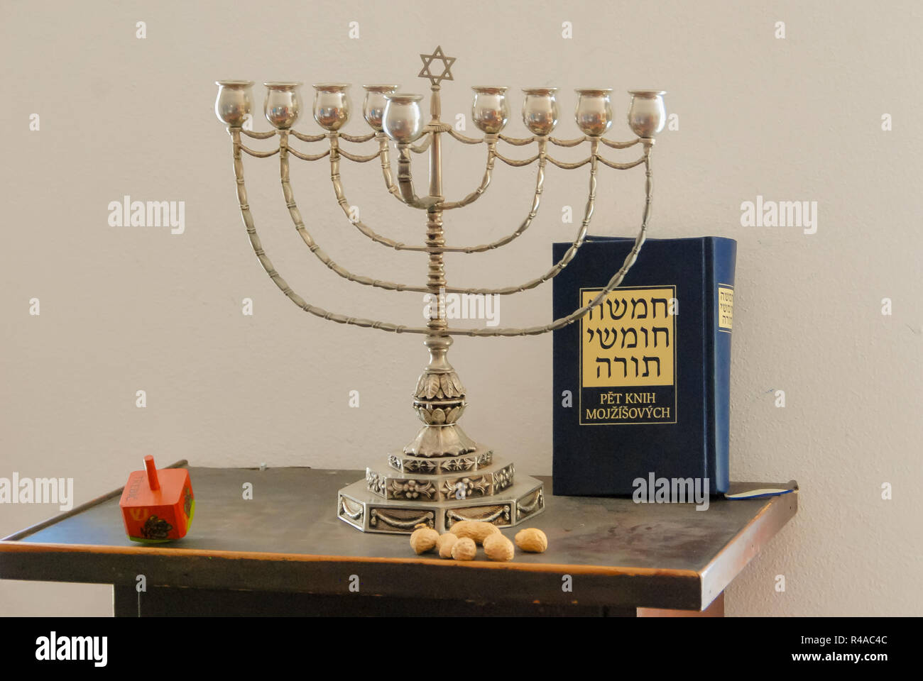 Hanukkia (candle holder), dreidl (jewish wood top) and the book of Torah (title in hebrew: The Pentateuch) for the jewish holiday of Hanukkah Stock Photo