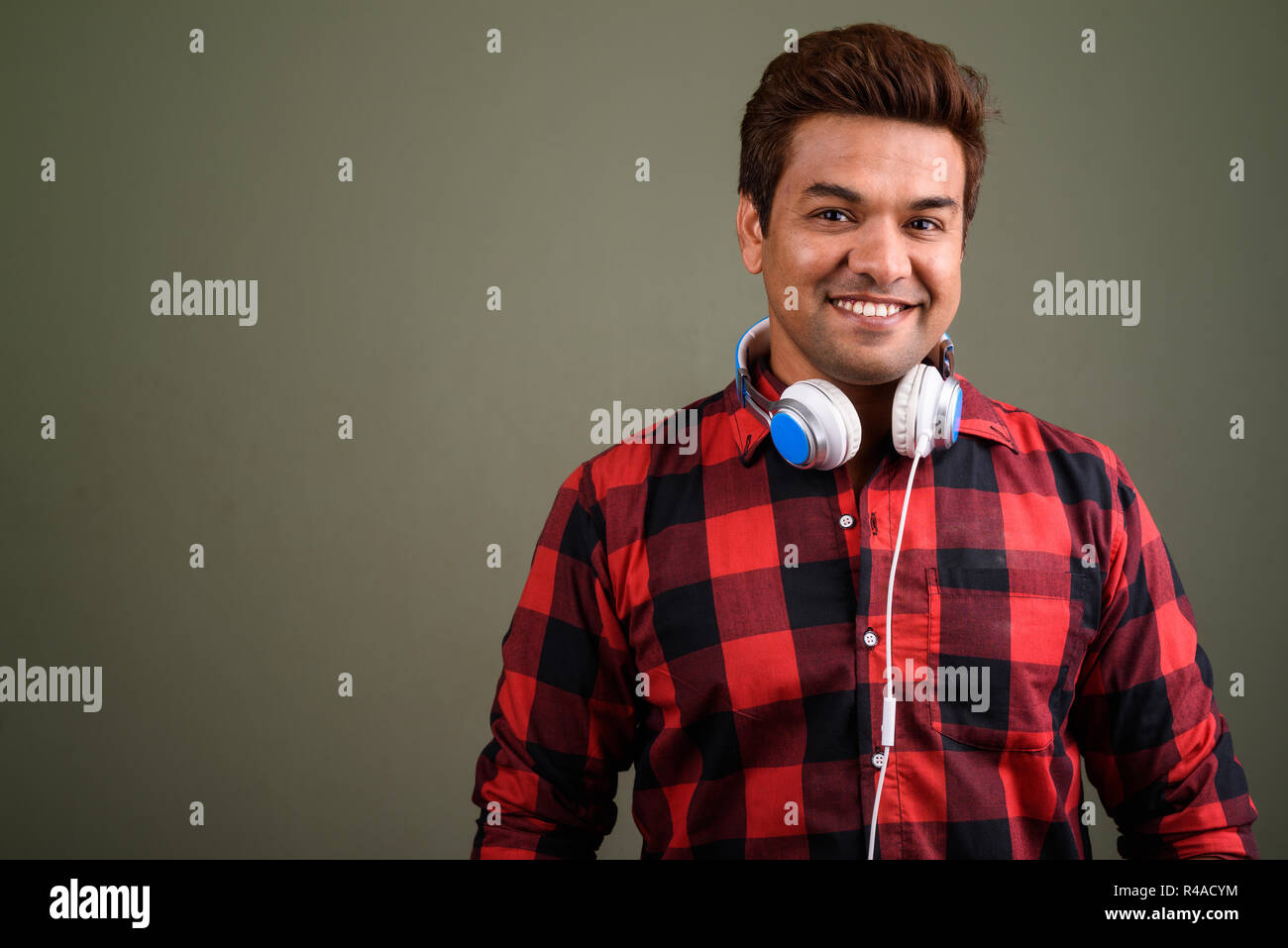 Indian man wearing headphones against colored background Stock Photo ...