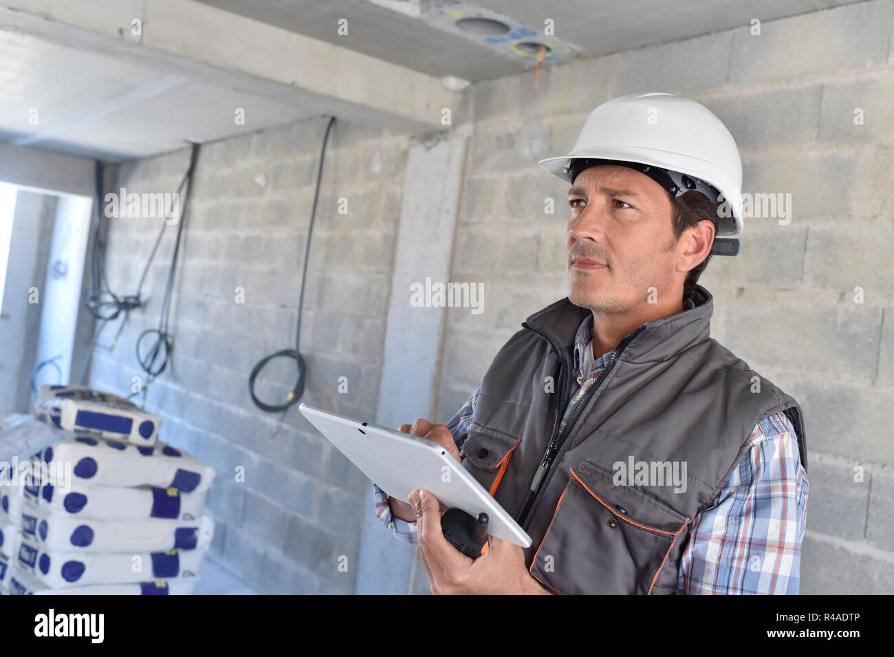 Construction manager using tablet on building site Stock Photo