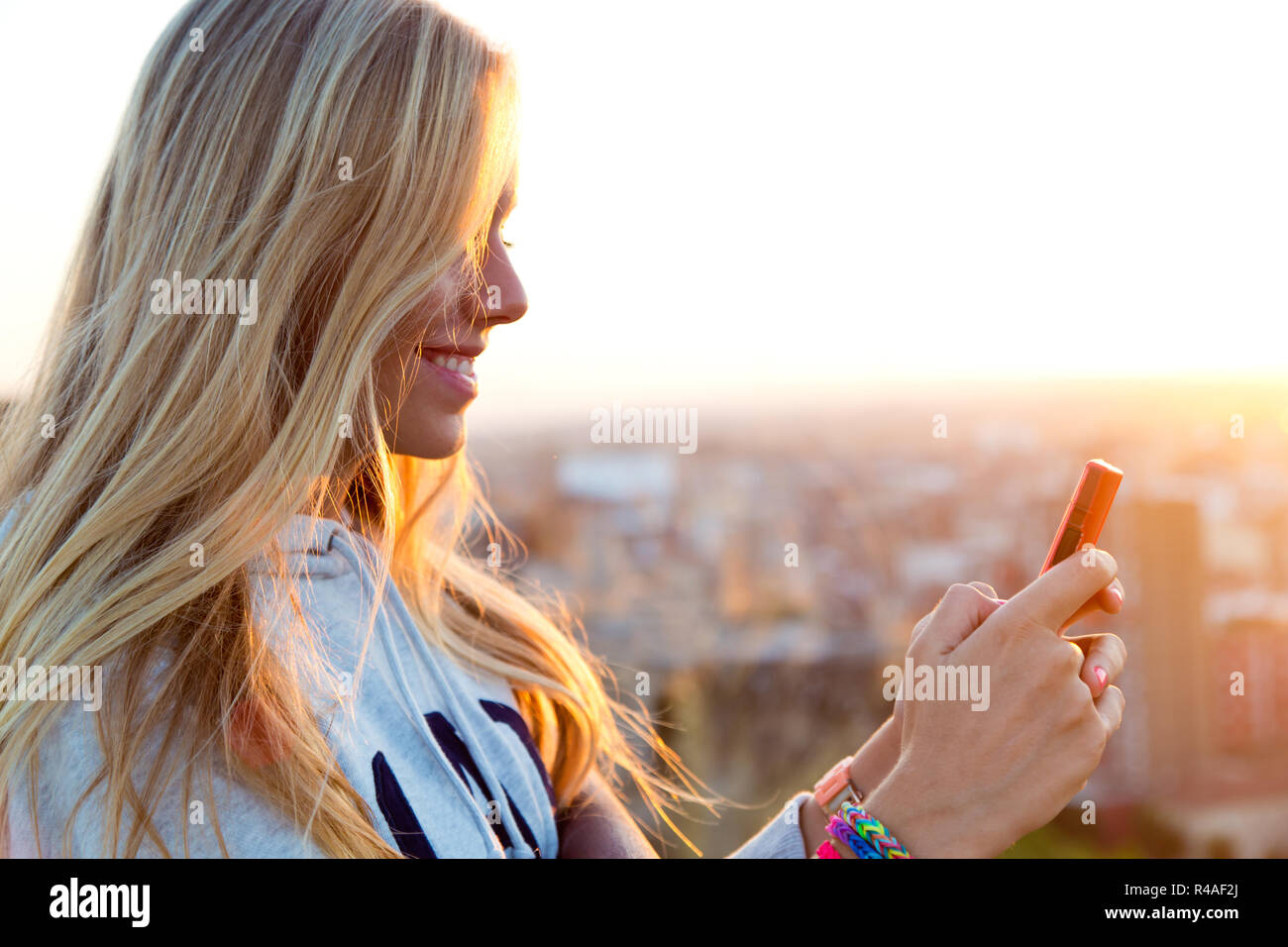 Beautiful blonde girl taking pictures of the city. Stock Photo