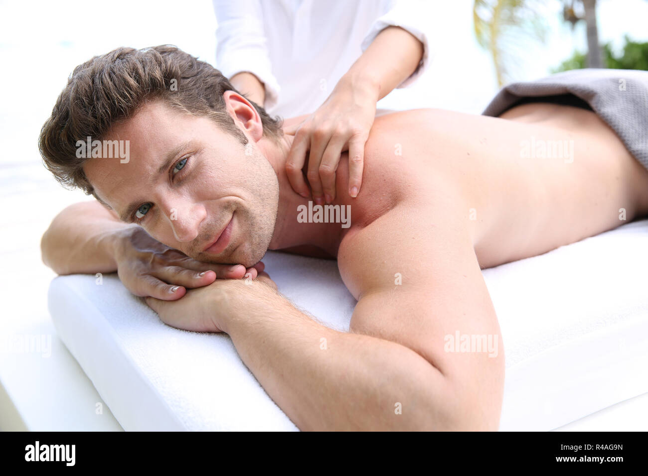 Handsome man laying on a massage bed Stock Photo