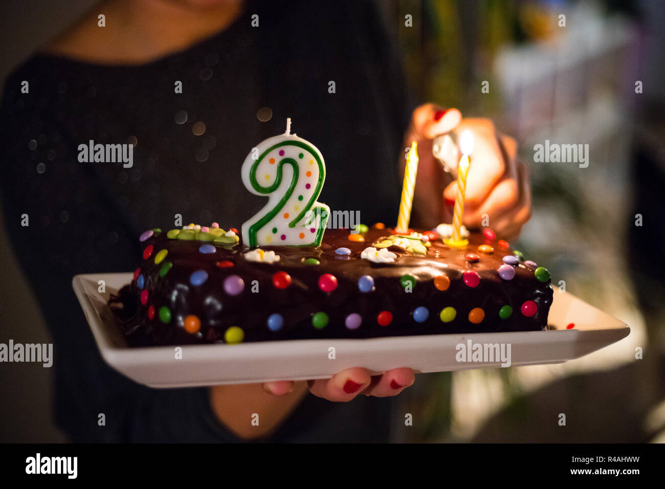 A Mother Lighting Her Child S Birthday Cake Stock Photo Alamy